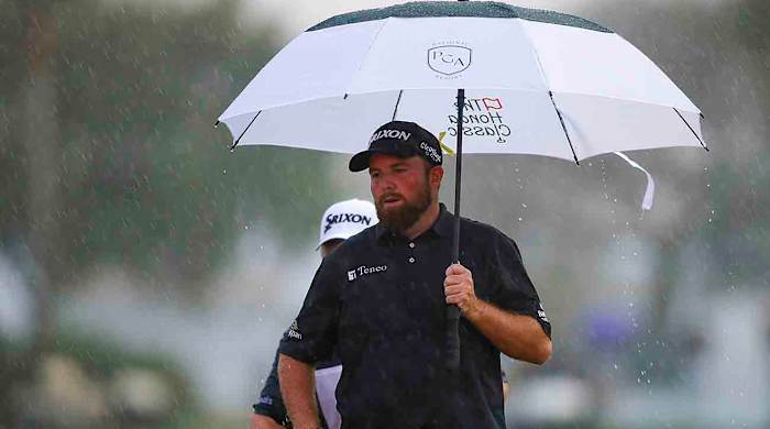 Shane Lowry holds an umbrella on the 18th hole in the final round of the 2022 Honda Classic.